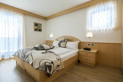 a bedroom with a large bed and a window at Ciasa Vilin in Corvara in Badia