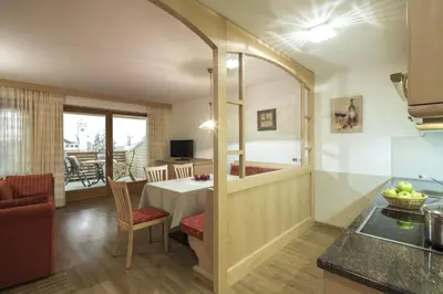 a kitchen and a dining room with a table at Ciasa Vilin in Corvara in Badia