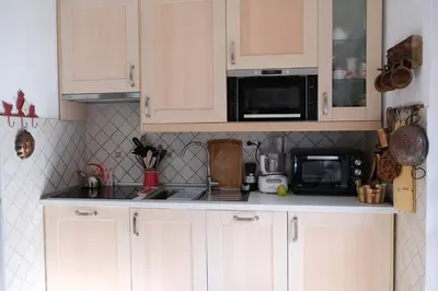 a kitchen with white cabinets and a microwave at Residence Fontanazzo in Campitello