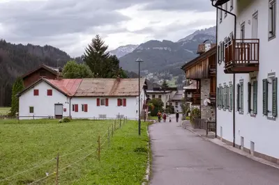 a street in a village with buildings and mountains at Residence Fontanazzo in Campitello
