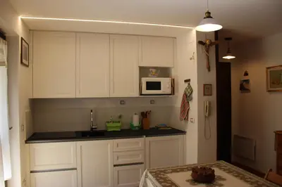 a kitchen with white cabinets and a microwave at Residence Fontanazzo in Campitello