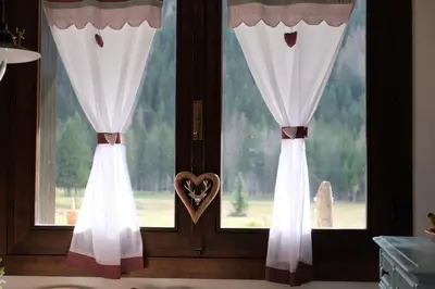a pair of curtains with a heart in a window at Residence Fontanazzo in Campitello