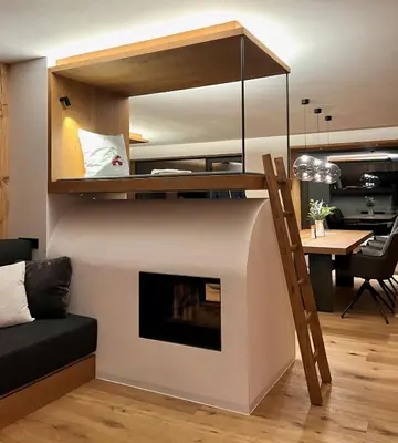 a living room with a fireplace and a loft at Egger 5 in Sorafurcia