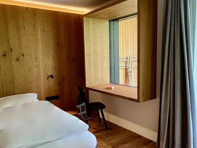 a bedroom with a bed and a desk and a window at Egger 5 in Sorafurcia
