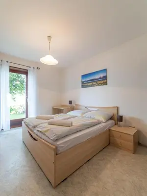 a bedroom with a large bed and a window at Plonhof Ferienwohnungen in Termeno