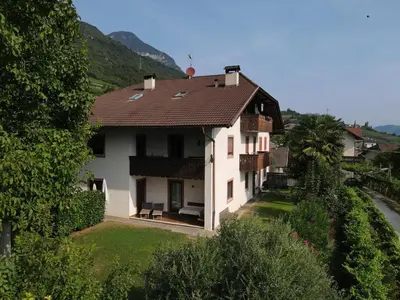 a white house with a brown roof at Plonhof Ferienwohnungen in Termeno
