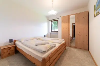 a bedroom with a large bed and a mirror at Plonhof Ferienwohnungen in Termeno