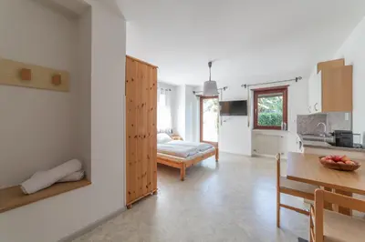 a kitchen and dining room with a table and a room at Plonhof Ferienwohnungen in Termeno