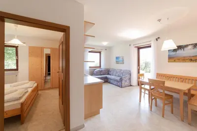 a kitchen and living room with a table and a couch at Plonhof Ferienwohnungen in Termeno