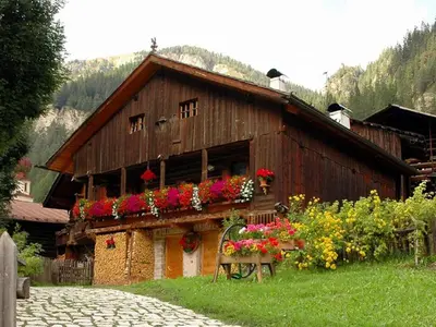a house with flowers on the side of it at Tobià Gries in Canazei