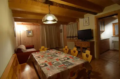 a living room with a table and a television at Tobià Gries in Canazei