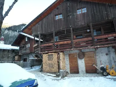 a large wooden building with snow on the ground at Tobià Gries in Canazei