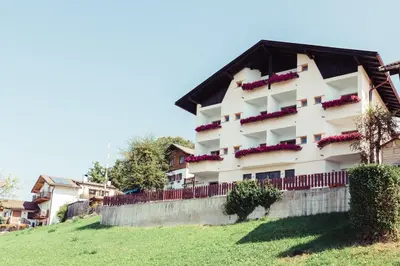 a building on a hill with flowers on it at Pension Stern in Aldino