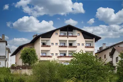 a large white building with a black roof at Pension Stern in Aldino