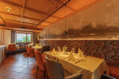 a restaurant with tables and chairs in a room at Pension Stern in Aldino
