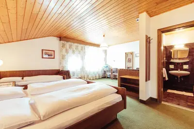 a room with three beds and a sink in it at Pension Stern in Aldino