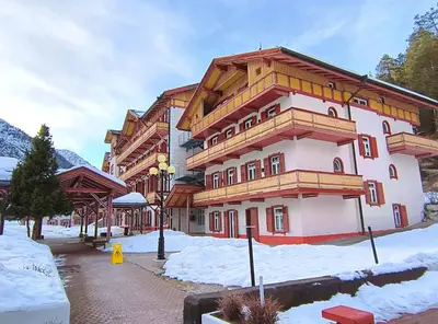 a large building with snow in front of it at Appartaments Lavaredo in Carbonin