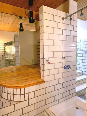 a bathroom with a white tile wall at Appartaments Lavaredo in Carbonin