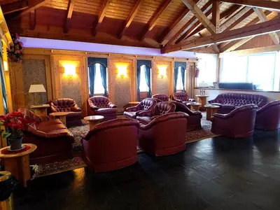 a living room with couches and tables and windows at Appartaments Lavaredo in Carbonin