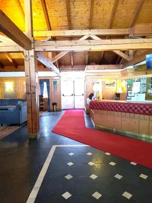a living room with a red rug and a couch at Appartaments Lavaredo in Carbonin