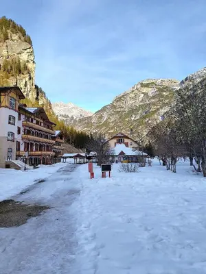 a snow covered street with buildings and mountains at Appartaments Lavaredo in Carbonin
