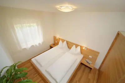 a white bed in a room with a window at Ferienwohnungen Waldruhe in Santa Valburga St. Walburg