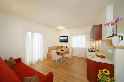 a kitchen and a living room with a red couch at Ferienwohnungen Waldruhe in Santa Valburga St. Walburg