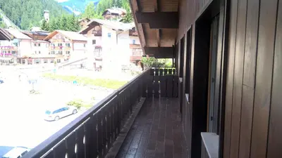 a balcony of a building with a view of a street at Stella Alpina in Campitello di Fassa