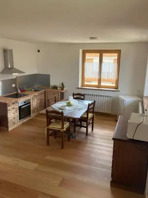a kitchen with a table and chairs in a room at Climb house Geremia in Selva di Cadore
