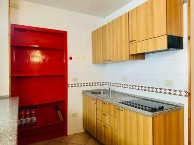 a kitchen with a sink and a red refrigerator at Appartamento nel cuore della Val di Fassa in Campestrin
