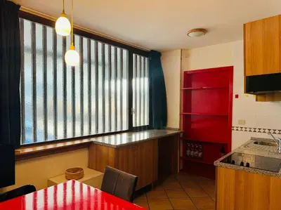 a kitchen with a red refrigerator and a red table at Appartamento nel cuore della Val di Fassa in Campestrin