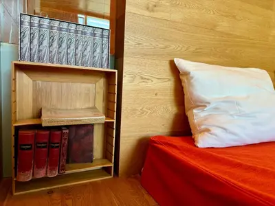 a bedroom with a bed and a book shelf with books at Die Bücherstube im living Kampill in Bolzano