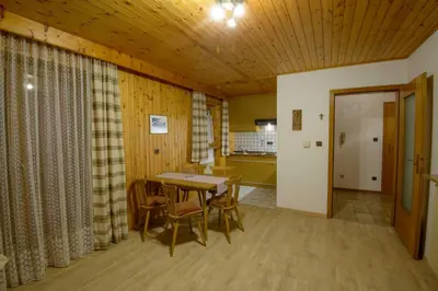 a dining room with a table and chairs and a kitchen at Appartement Alpenblick in Valdaora