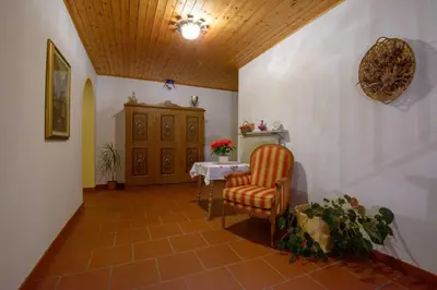 a hallway with a table and a chair in a room at Appartement Alpenblick in Valdaora