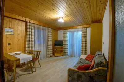 a living room with a bed and a table and a dining room at Appartement Alpenblick in Valdaora
