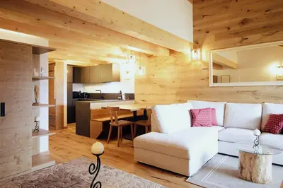 a living room with a television on a wooden wall at SKYWAY LOFT - Residence Veronza con piscina, Dolomiti Affitti in Cavalese