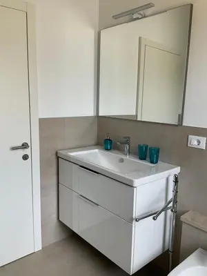 a bathroom with a white sink and a mirror at Appartamento Adele in Merano