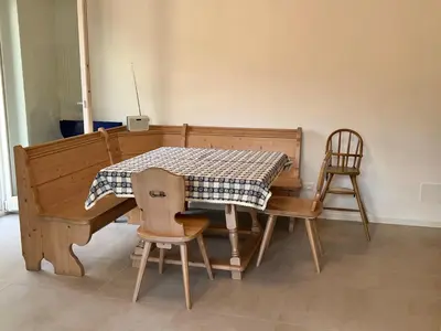 a dining room table with a table and two chairs at Appartamento Adele in Merano