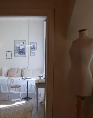 a mannequin in front of a room with a table at Casa Fellin 1891 B&B in Cles