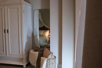 a room with a bedroom with a mirror and a chair at Casa Fellin 1891 B&B in Cles