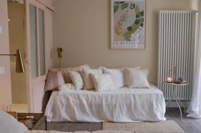 a living room with a bed with white sheets and pillows at Casa Fellin 1891 B&B in Cles