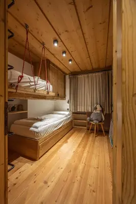 a bedroom with two bunk beds and a chair at Casa dell Alpinista a Cortina d Ampezzo in Cortina dʼAmpezzo