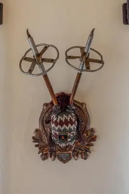 a clock on a wall with three swords on it at Casa dell Alpinista a Cortina d Ampezzo in Cortina dʼAmpezzo