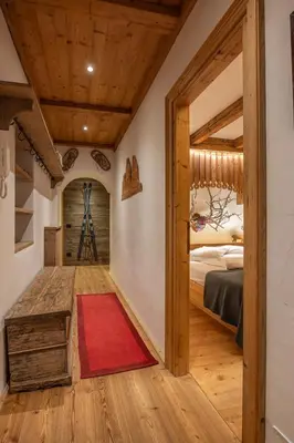 a room with a red rug and a bedroom at Casa dell Alpinista a Cortina d Ampezzo in Cortina dʼAmpezzo