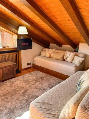 a living room with two beds and a tv at Chalet vicino le piste da sci in Pocol