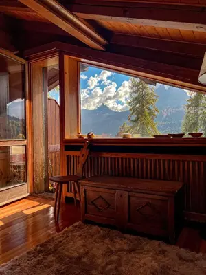 a room with a large window with a chair and a table at Chalet vicino le piste da sci in Pocol