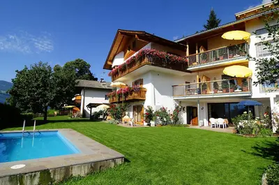 a house with a swimming pool in front of a yard at Haus Rosengarten in Tirolo