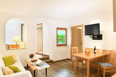 a living room with a table and a couch at Haus Rosengarten in Tirolo
