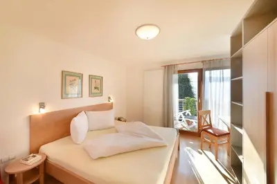 a small bedroom with a bed and a window at Haus Rosengarten in Tirolo