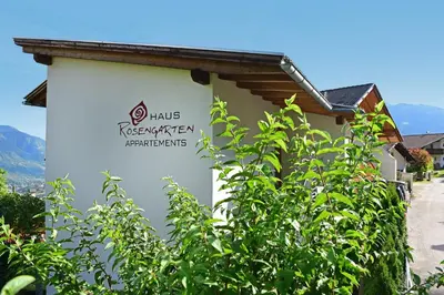 a building with a sign on the side of it at Haus Rosengarten in Tirolo